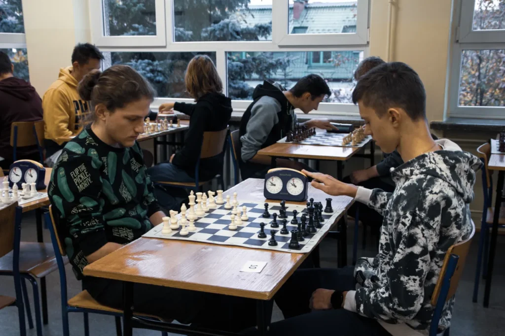 Zdjęcie przedstawia turniej szachowy, uczestników