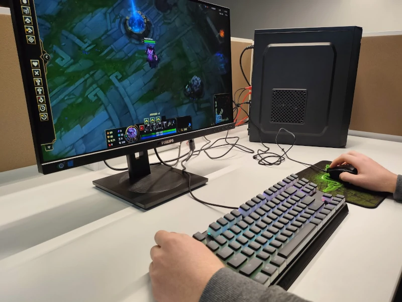 Monitor z wyświetloną grą, klawiatura i jednostka centralna na biurku